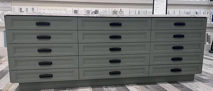Close-up of kitchen detail with grey furniture and white countertop, blending modern tones with clean design.