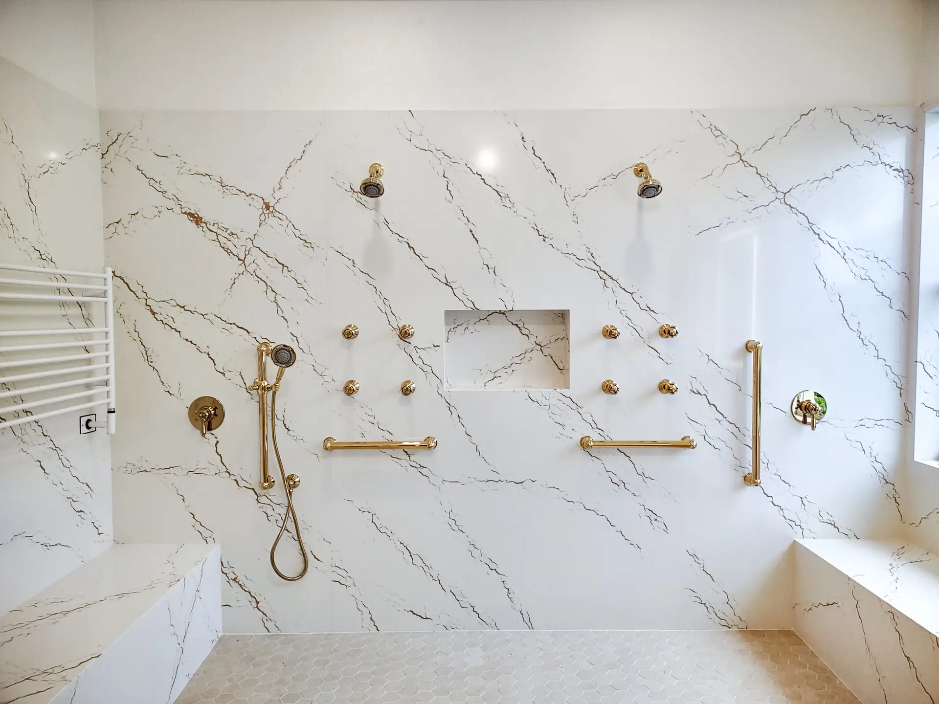 Close-up view of shower walls in a remodeled Venice, Florida master bathroom, showcasing seamless Cambria Inverness Gold quartz installation for a sleek, modern look. master bathroom walk-in shower ideas.