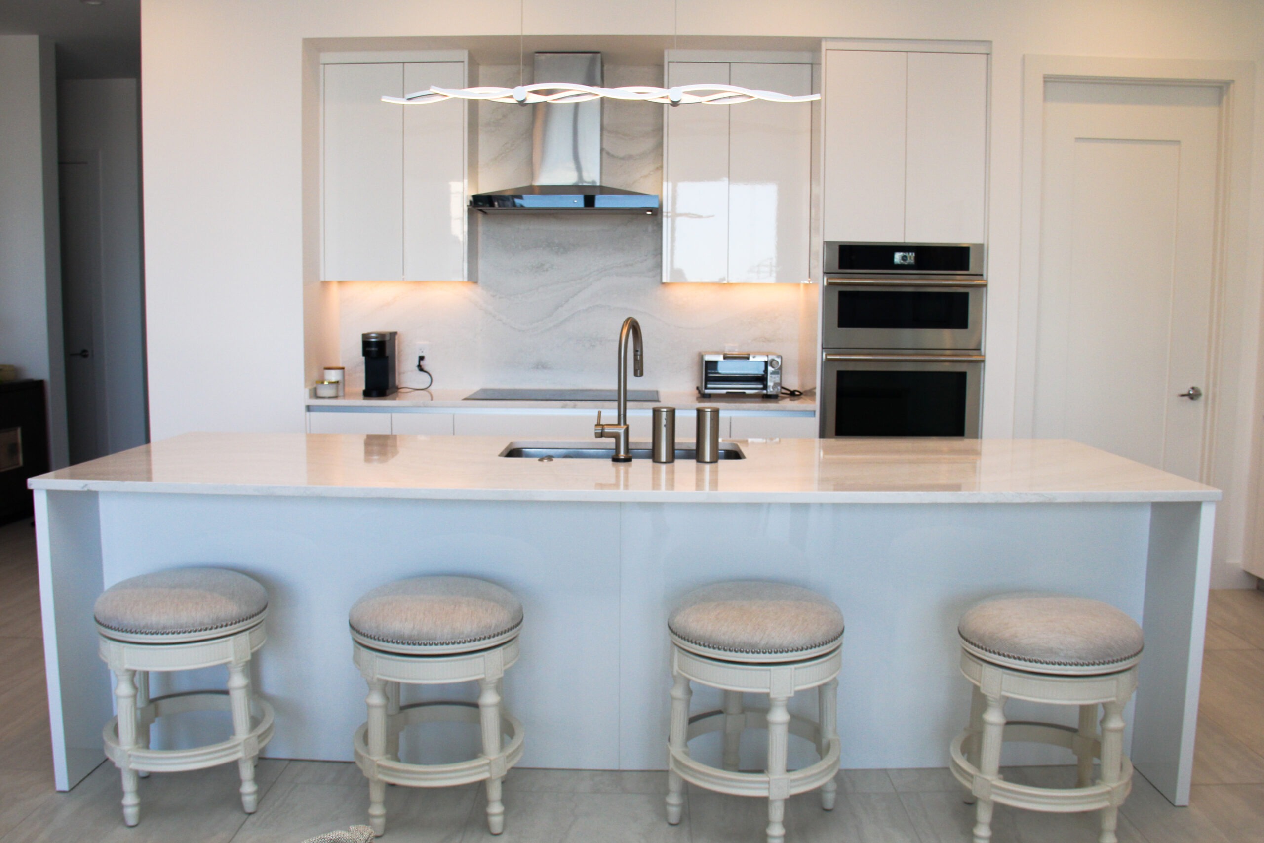 Light-colored modern kitchen in Sarasota, FL with warm tones, soft lighting, and minimalist design—creating a cozy and inviting space aligned with 2025 kitchen trends.