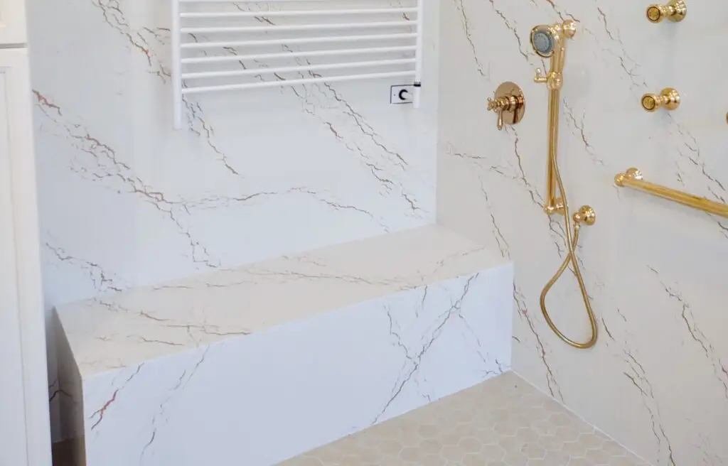 master-bathroom-walk-in-shower-ideas Close-up view of shower walls in a remodeled Venice, Florida master bathroom, showcasing seamless Cambria Inverness Gold quartz installation for a sleek, modern look.Master bathroom walk-in shower ideas